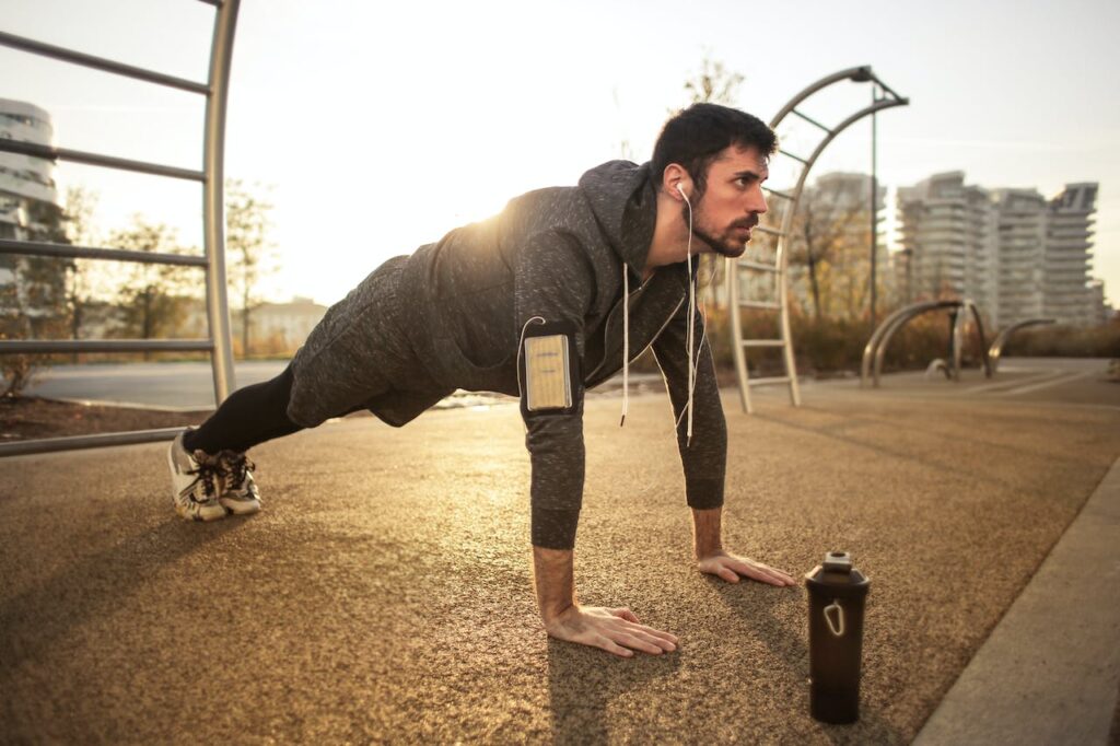 What is your fitness truth Jan 2024. Man doing a plank in a public park in the morning.