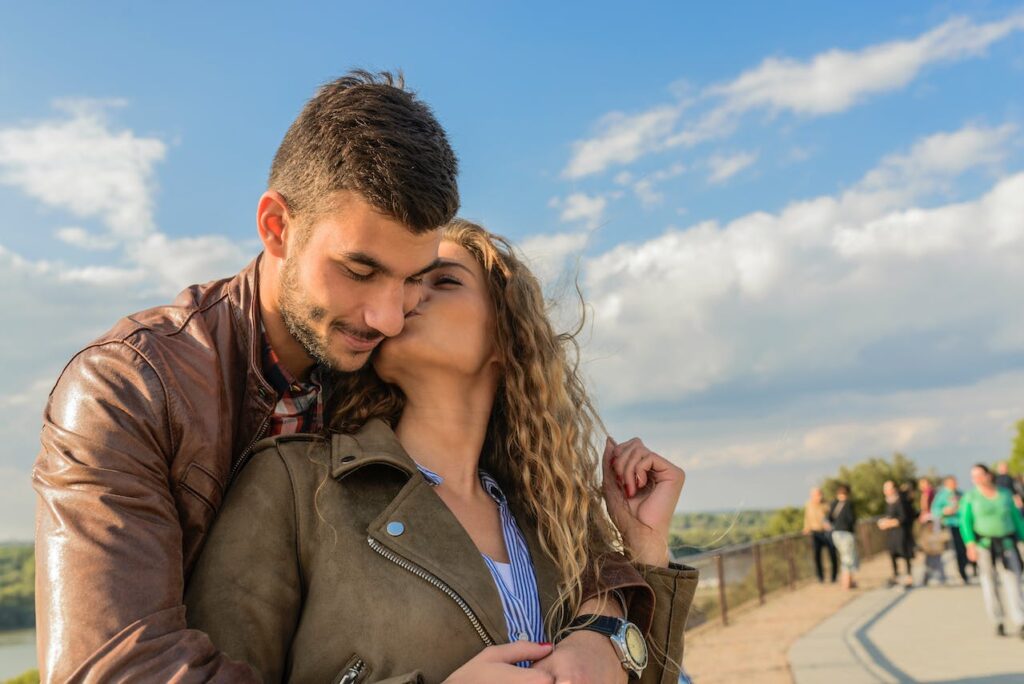 man and woman showing affection as the woman kisses the man on the cheek